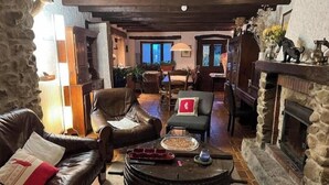 A cozy living room with a stone fireplace, leather sofas, and a coffee table. - L'art de Vivre Avec la Nature (Fillinges)
