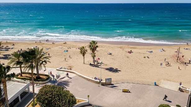 A beach with people sunbathing and walking along the shore. - Front line apartment at Arenal Beach (Calpe)