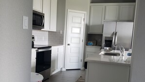 A modern kitchen with white cabinets, a stainless steel refrigerator, a microwave, and a built-in oven. - Furnished clean newly room. No pet, smoking or party (Jarrell)