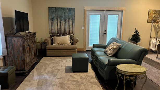 A living room with a sofa, ottoman, and a coffee table.