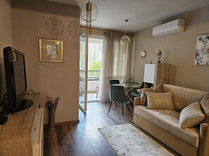 Una sala de estar moderna con un sofá, una mesa de comedor y un televisor.