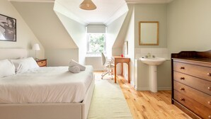 Une chambre à coucher comprenant un lit, un bureau, une chaise, une commode, un miroir et une fenêtre.