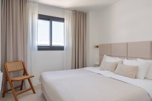 A hotel room with a bed, a chair, and a window with curtains. - Stylish Luxury Suite with Terrace in Higueron (Fuengirola)
