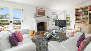 Ein Wohnzimmer mit Kamin, Fernseher und Bücherregal.
