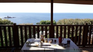 A table set on a balcony with a view of the sea and a distant island. - 2 bedroom mobile home in saint-raphaã "l (Saint-Raphaël)
