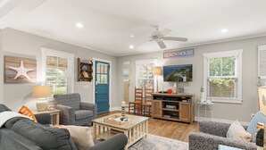A living room with a ceiling fan, a blue door, and a sign that reads "BEACH HOUSE". - The Beach is calling you at The Porch Side Cottage, sleeps 9 (St Simons Island)