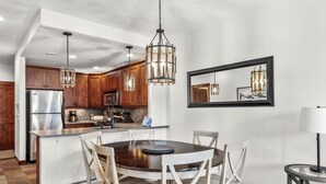 A modern kitchen with wooden cabinets, stainless steel appliances, and a central island with seating.