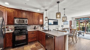 A modern kitchen with wooden cabinets, stainless steel appliances, and a central island.