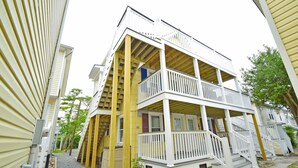 A multi-story building with a balcony on the second floor and a covered porch on the ground floor.