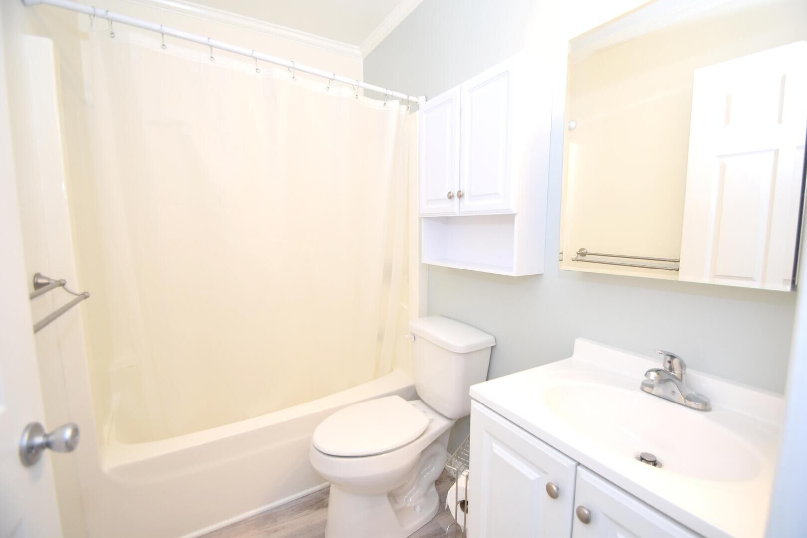 Une salle de bain équipée d’une baignoire, de toilettes, d’un lavabo et de meubles de rangement.