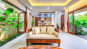 A modern living room with a sofa, a coffee table, and a kitchen in the background.