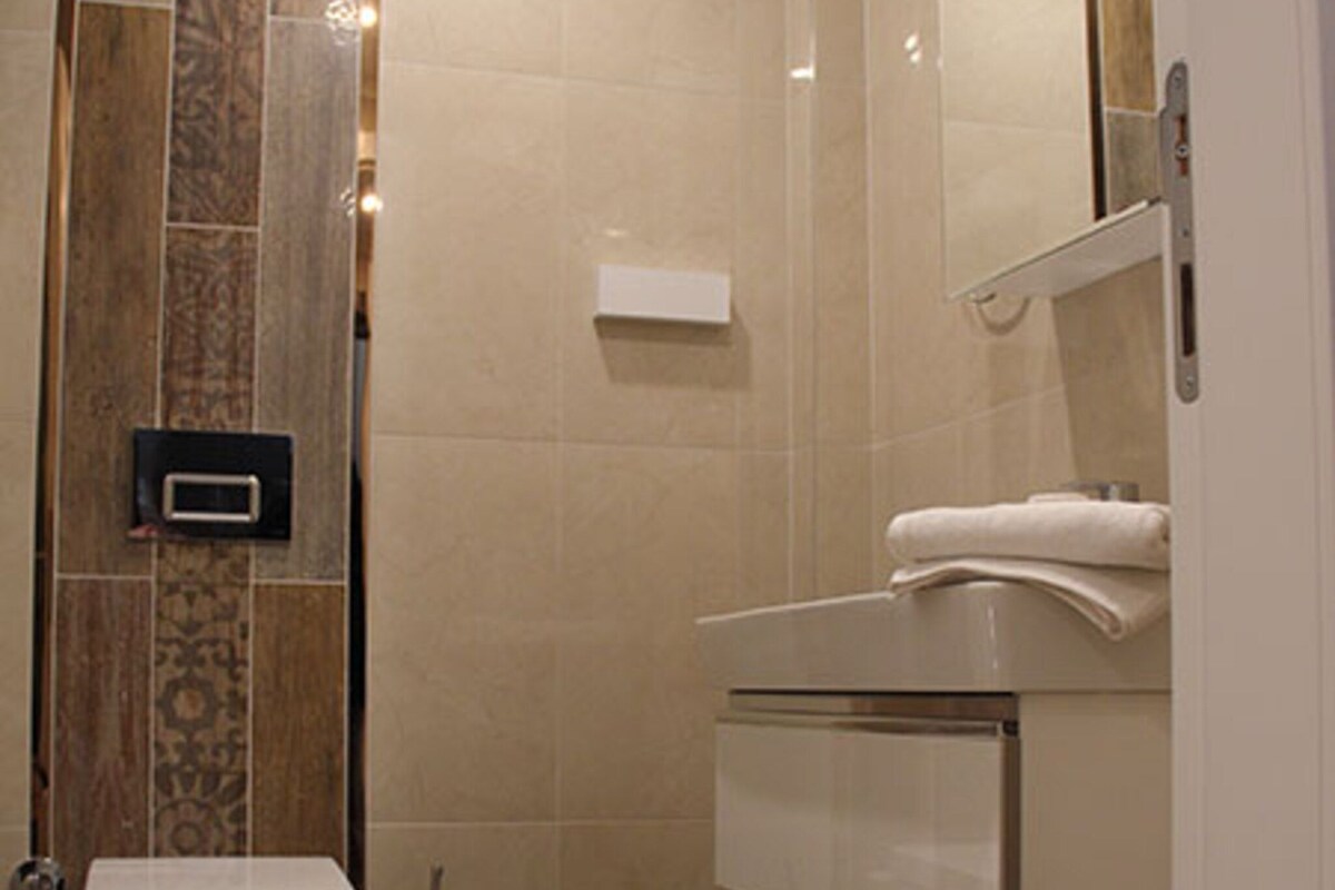 A bathroom with a toilet, bidet, and a sink with a mirror.