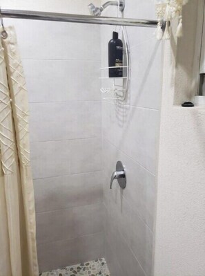 Chuveiro, toalhas de banho, sabonete, papel higiênico