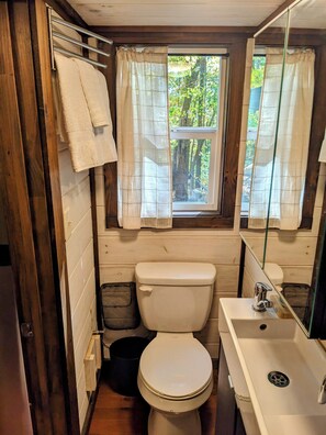 Un baño pequeño con inodoro, lavabo y ventana.