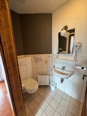 A bathroom with a toilet, sink, and radiator. - Schloss Hotel Kastellaun (Kastellaun)