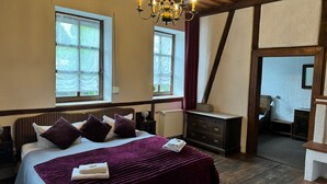 A bedroom with a large bed, a wooden ceiling, and a chandelier. - Schloss Hotel Kastellaun (Kastellaun)
