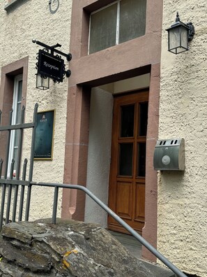 A building with a reception sign, a wooden door, and a stone wall. - Schloss Hotel Kastellaun (Kastellaun)