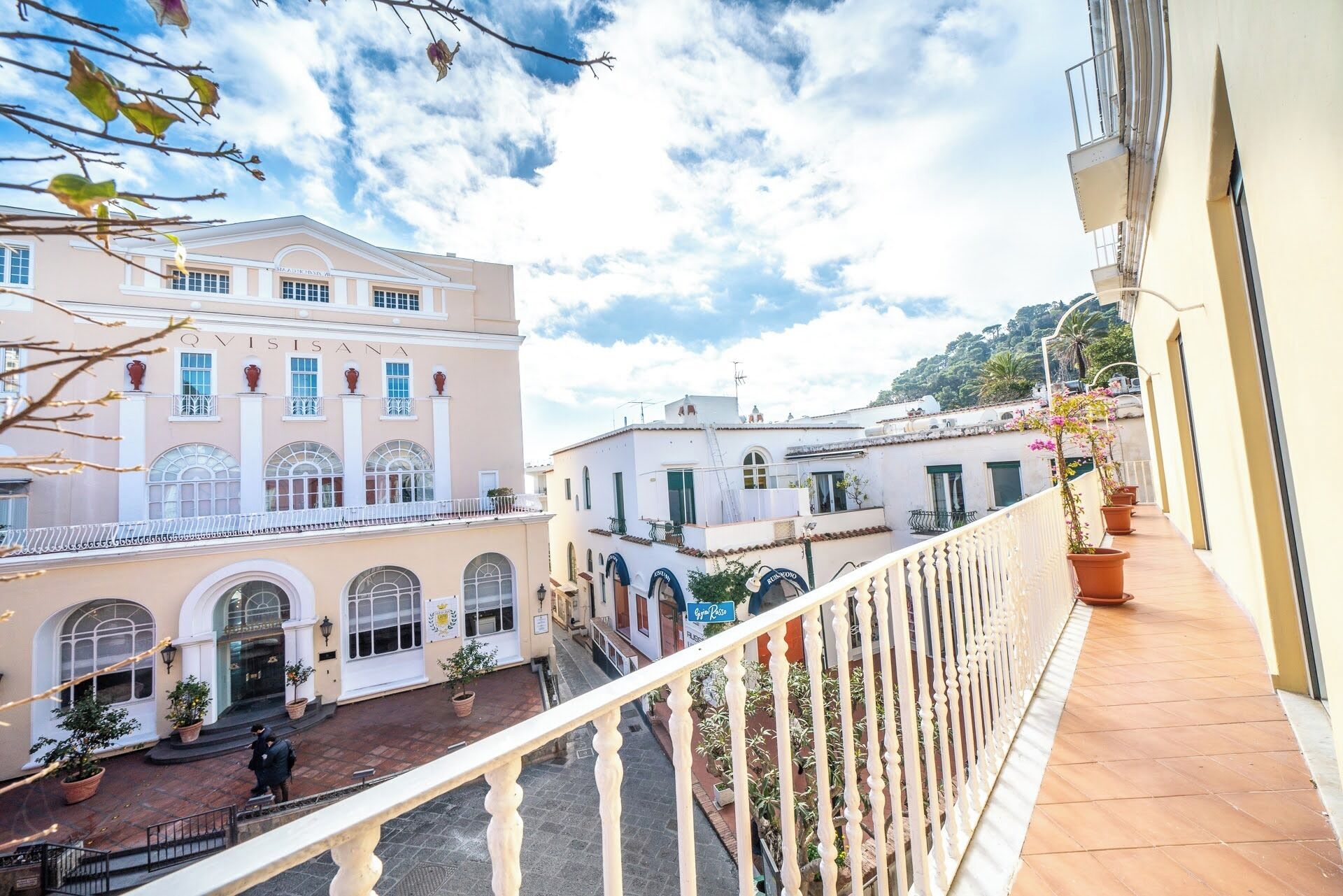 A building with a balcony, a street in front, and a clear sky.