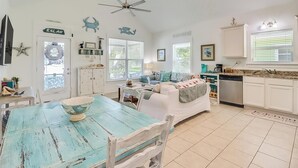 A spacious living area with a dining table, sofa, and kitchen area. - Parrothead Escape-3BD/2BA- 1 block from beach - Pet Friendly (Gulfport)