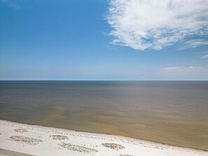 Ein Strand mit blauem Himmel und ruhigem Wasser.