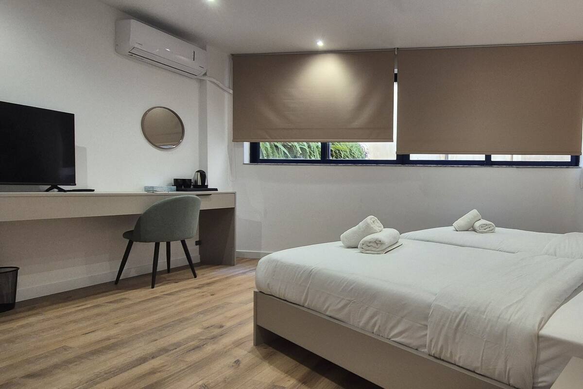 A modern bedroom with a bed, a desk, and a chair.