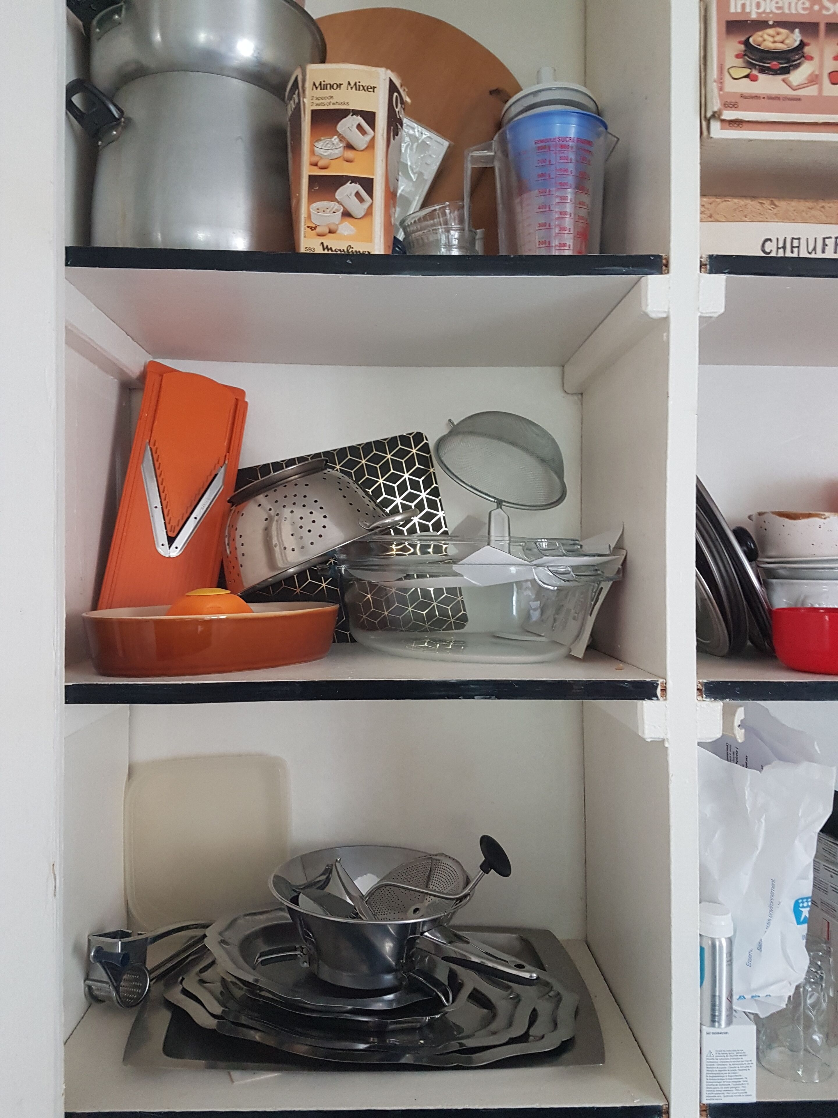 Une cuisine équipée d’une variété d’ustensiles et d’appareils de cuisine, notamment un batteur, une passoire et une casserole.