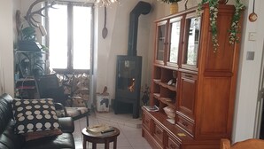 Un soggiorno con camino, un divano, un tavolino da caffè e un mobiletto in legno.