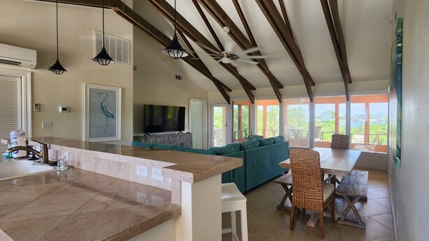 Amplia sala de estar con cocina, mesa de comedor y asientos.