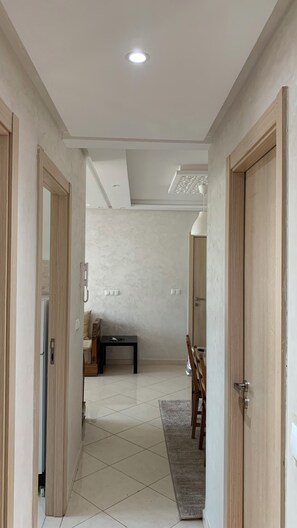 Stunning hallway leads to a dining area with a table and comfortable seating.