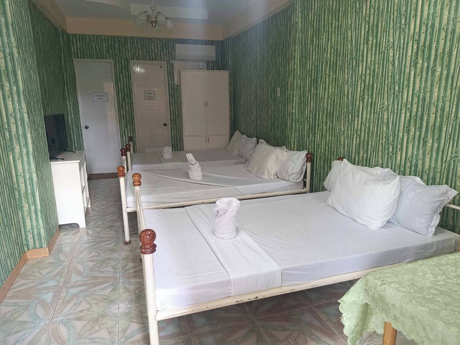 Una habitación de hotel con dos camas, un escritorio y un armario.