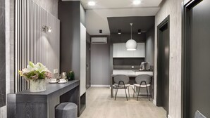 Een moderne keuken met een centraal eiland, twee stoelen en een hanglamp.