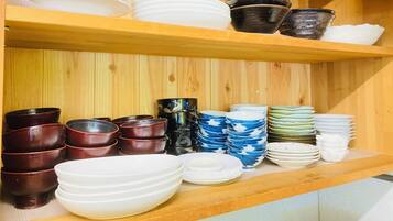 A wooden shelf with various bowls and plates.