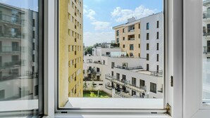 A view from a window of a multi-story building with balconies and a courtyard.