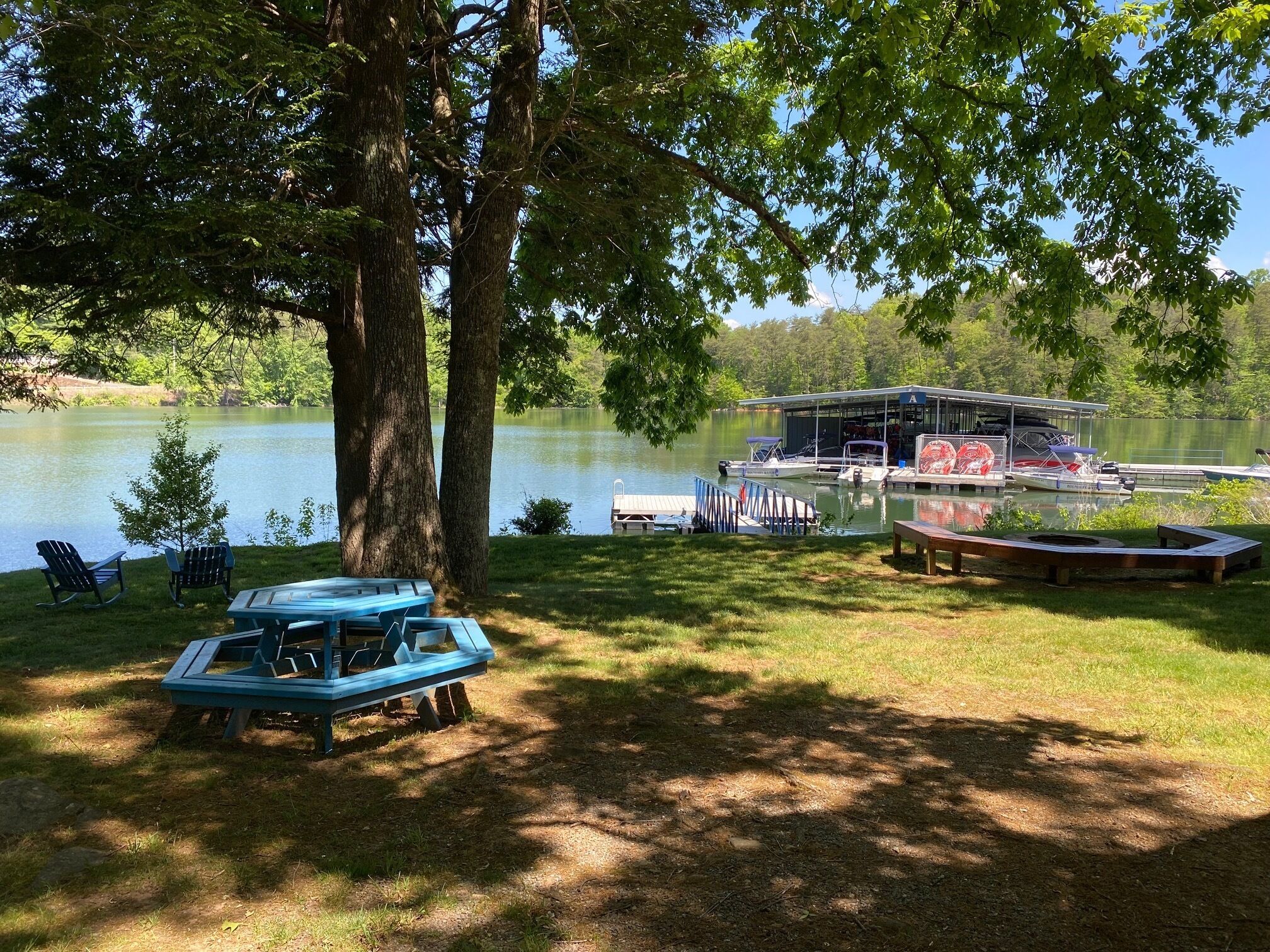 Une propriété au bord du lac, dotée d’un quai, de bateaux et d’une structure abritée.