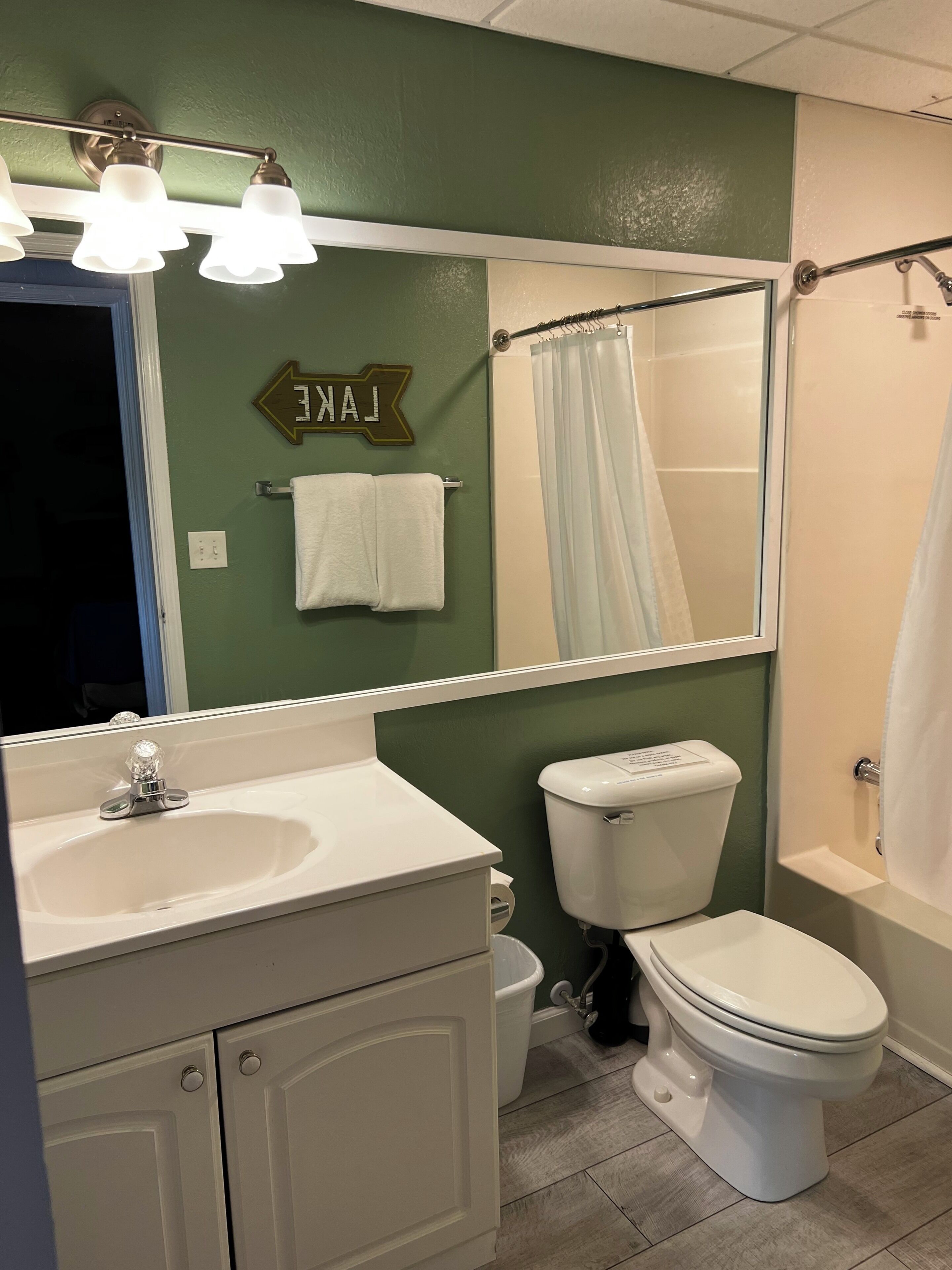Un baño con lavamanos, inodoro y cortina de ducha.
