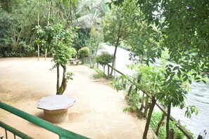 A sandy area with a concrete bench and a railing. - Ceylon Adventure Sports (Kithulgala)