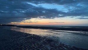 A beach with a wide sandy shore and a calm sea. - Seaside Haven Coastal Comfort 200m from the Beach (Margate)