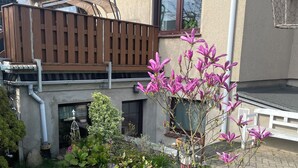 A residential house with a well-maintained garden, a wooden deck, and a visible window. - 1 Bedroom Apartment in Zierow (Zierow)