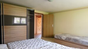 A bedroom with a bed, a wardrobe, and a small desk. - 1 Bedroom Apartment in Zierow (Zierow)