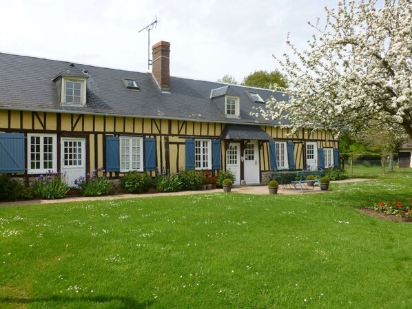 A traditional half-timbered house with a symmetrical facade, a central entrance, and a well-maintained garden with flowering plants and a lawn. - 4 Bedroom Agritourism property in Conteville (Conteville)
