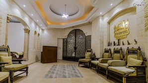 A luxurious lobby with ornate furniture, a grand staircase, and a prominent hotel sign. - Pyramids Golden Gate Hotel (Giza)