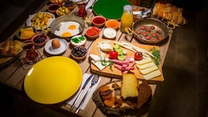 A breakfast spread with various foods and drinks on a wooden table. - Pyramids Golden Gate Hotel (Giza)