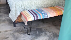 Une chambre à coucher avec un lit, des rideaux verts, un miroir et une plante en pot.