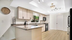 A modern kitchen with a central island, built-in appliances, and a skylight.