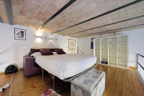 Une chambre à coucher comprenant un lit, un canapé, une petite table, une armoire et une fenêtre donnant sur un beau paysage.