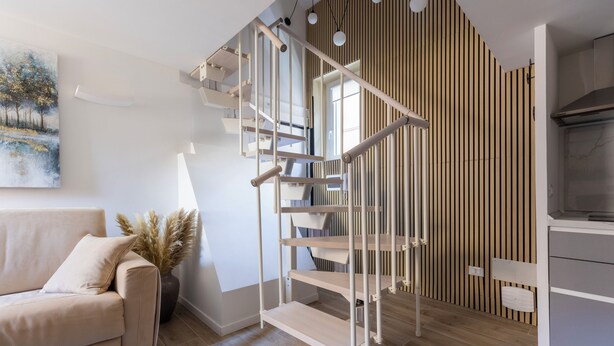 A modern interior with a staircase, a sofa, and a painting. - Delightful apartment in Trastevere on two levels MauveSweetRhome 3 (Roma)