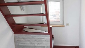 Een trap met een rode leuning en een houten vloer.