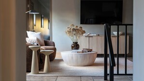 Een moderne woonkamer met een bank, salontafel en decoratieve vaas.