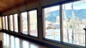 A long room with large windows and a wooden floor. - Largest Cabin Available for Rent in Cucahra! 26+ (La Veta)