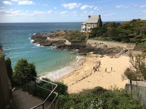 A coastal beach with a stone house, rocky cliffs, and a clear view of the ocean. - T2 Apartment Near the Beaches, Saint-Malo (Saint-Malo)